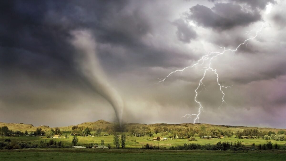 Powerful tornado approaching beneath dark, turbulent storm clouds at night